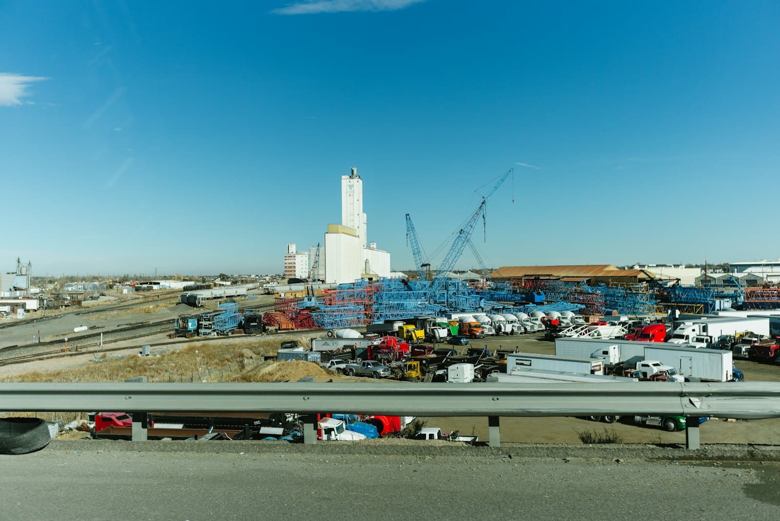 Industrial complex with silos and construction cranes
